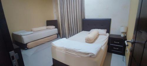 a small room with two beds and a mirror at Aldeoz Group House Palembang in Palembang