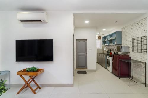 a living room with a flat screen tv on a wall at Alcove 1BHK Bandra W by The Bombay Home Company in Mumbai