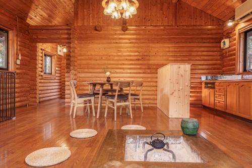 a dining room with a table and chairs in a log cabin at VILLA ATAMI -Maruta- in Atami