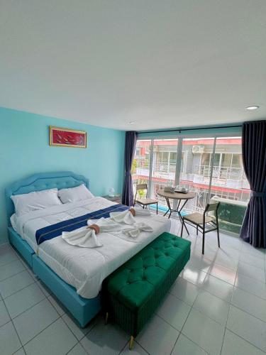 a bedroom with a bed and a table and chairs at Ocean Blue Huahin Guesthouse in Hua Hin