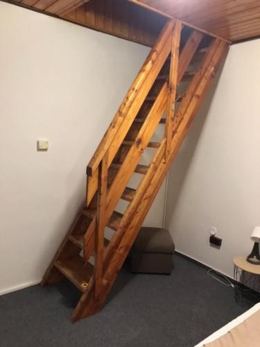 a wooden staircase in a room with a white wall at Penzión Zátoka in Liptovský Mikuláš
