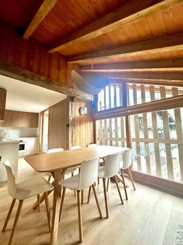 - une table à manger et des chaises dans la cuisine dans l'établissement Le tilleul-cœur du village, à Samoëns