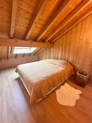 - une chambre dans une cabane en bois avec un lit dans l'établissement Le tilleul-cœur du village, à Samoëns