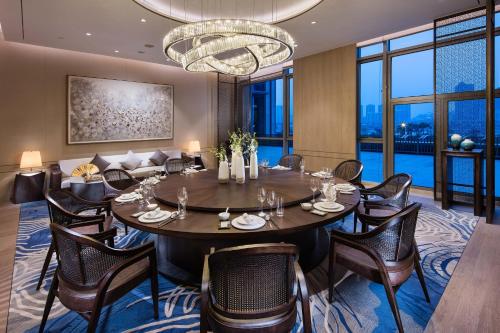 a dining room with a table and chairs and a chandelier at Hilton Quanzhou Riverside in Quanzhou