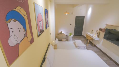 a room with a bed and a tv on a wall at 咻咻宿 Xiuxiu 電梯宅 in Taitung City