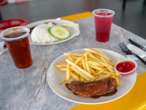 a table with two plates of food with french fries at Ho Hotel in Melaka