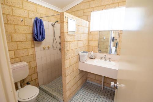 a bathroom with a toilet and a sink and a shower at Belair Gardens Caravan Park in Geraldton