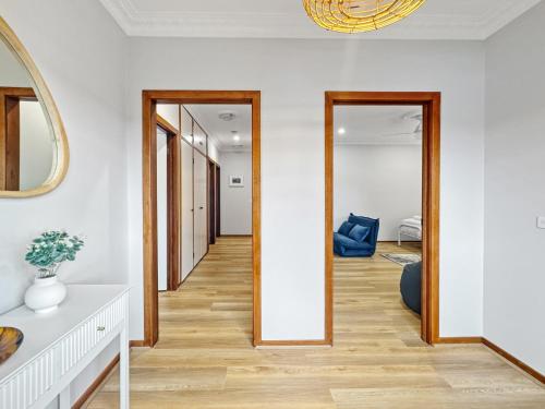 a hallway with white walls and a mirror at 4-Bed Beach House with Garden & Alfresco Dining in Tomakin