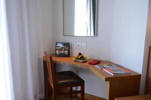 a wooden desk with a chair and a mirror at Swiss-Belinn Luwuk in Luwuk