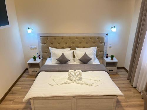a bedroom with a large bed with a bow on it at AKS Hotel in Tashkent