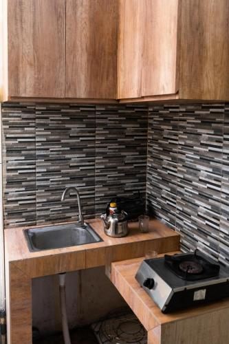 a kitchen with a sink and a stove at Homestay Syariah Bayt in Pekalongan