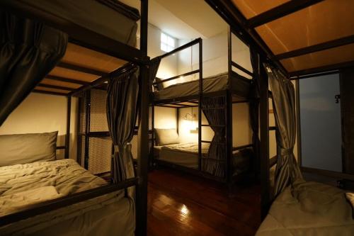 two bunk beds in a room with a window at Amahostel in Ban Thalat Choeng Thale