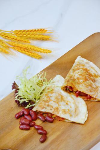 a wooden cutting board with some food on it at Junluxe Hotel Guangzhou Science City-Free Shuttle Bus Service to Guangzhou Canton Fair in Guangzhou