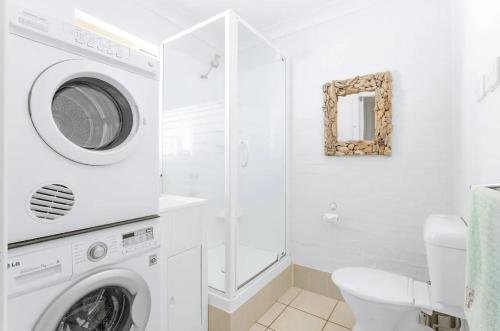 a white bathroom with a washing machine and a toilet at Huskisson Beach Holiday Villa by Experience Jervis Bay in Huskisson