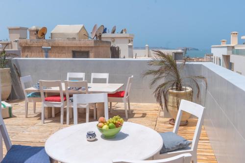 a table and chairs and a bowl of fruit on a balcony at Hanah Apartments by Living Essaouira in Essaouira