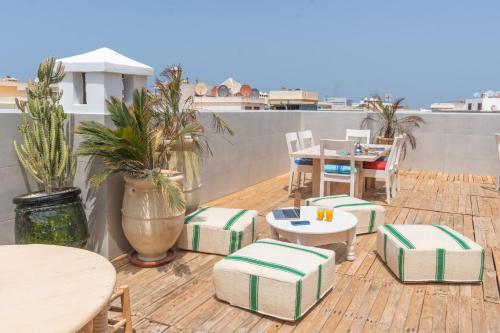 a patio with tables and chairs and tables on a roof at Hanah Apartments by Living Essaouira in Essaouira