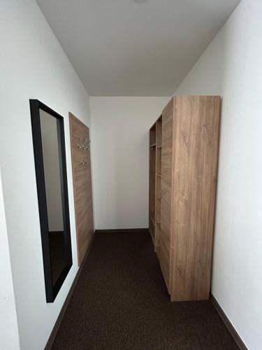 a room with a hallway with a mirror and wooden cabinets at Motel R10 in Mladá Boleslav