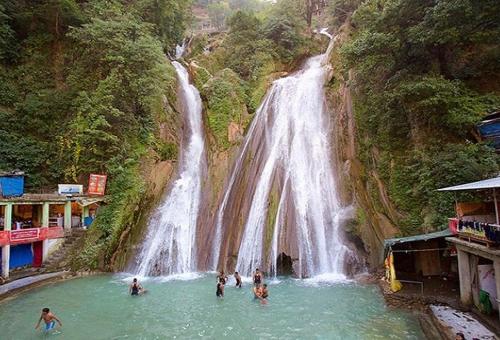 a group of people in the water in front of a waterfall at Icebergs Mussoorie - A Boutique stay and 24 hrs roof top cafe in Mussoorie
