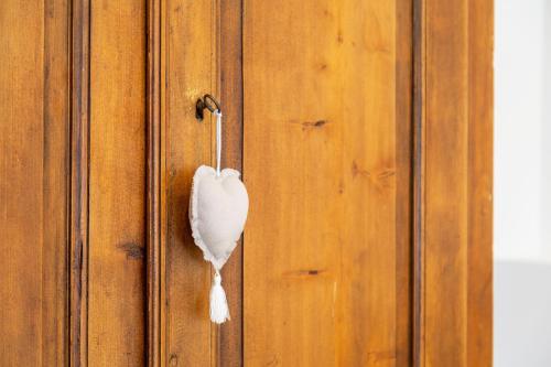 a white feather hanging on a wooden door at Alba's Home Pieve di Cadore in Pieve di Cadore