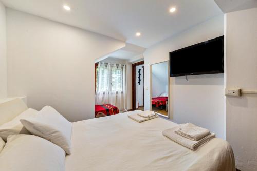 a bedroom with a large bed with two towels on it at Alba's Home Pieve di Cadore in Pieve di Cadore