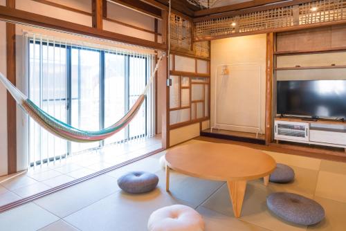 a living room with a table and a large window at GuestHouseYULLAT in Horiechō