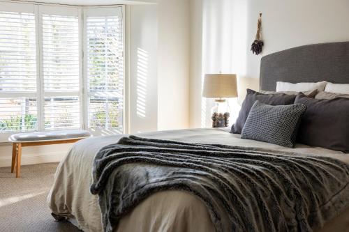 a bedroom with a large bed and a window at Seppeltsfield Vineyard Retreat - 3 Bedroom Holiday Home in Seppeltsfield