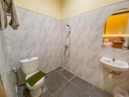 a bathroom with a toilet and a sink at Grand mansion hotel in Blitar