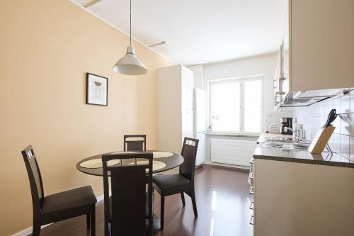 a kitchen with a table and chairs in a room at Tilava yksiö Port Arthurissa, iso keittiö in Iso-Heikkilä