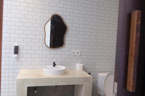 a bathroom with a sink and a mirror on the wall at Dipenida Bali in Sampalan