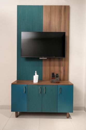 a blue cabinet with a television on a wall at VSC Porto Marina in Bālarāmpuram