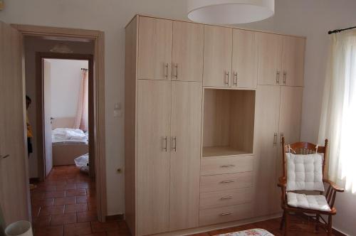 a large wooden cabinet in a room with a bedroom at Comfortable Apartment Near The Sea in Áyios Ilías