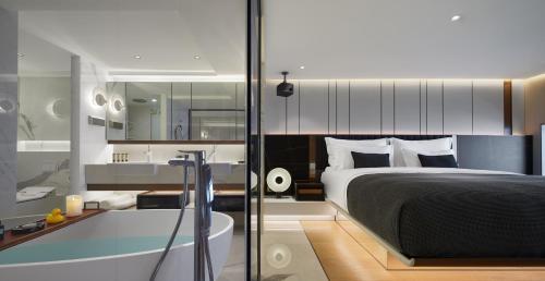 a bedroom with a large bed and a bath tub at ISEYA Serviced Apart-ment Chengdu Taikoo Li Flagship in Chengdu