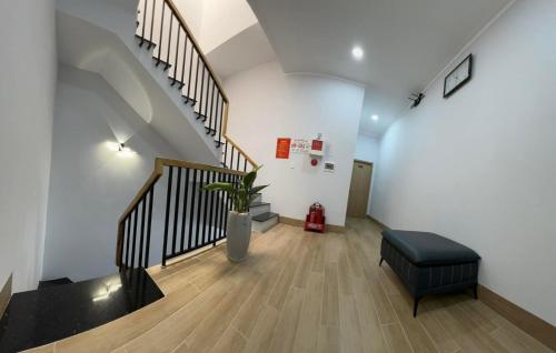 a hallway with a staircase with a plant and a stool at Tommie Homestay in Ấp Tân An (1)