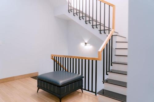 a stairway with a black ottoman and a stair case at Tommie Homestay in Ấp Tân An (1)
