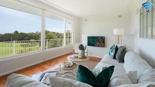 a living room with a couch and a large window at Adelong in Kiama Downs