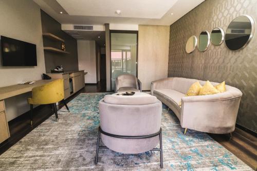 a living room with two chairs and a couch and a table at Happy Valley Hotel and Casino in Ezulwini