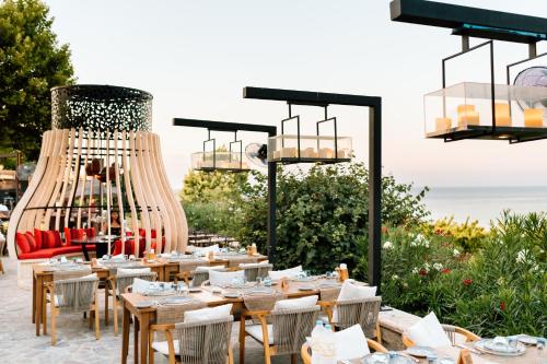 a restaurant with tables and a large chandelier at Lords Palace Hotel SPA Casino in Kérynia