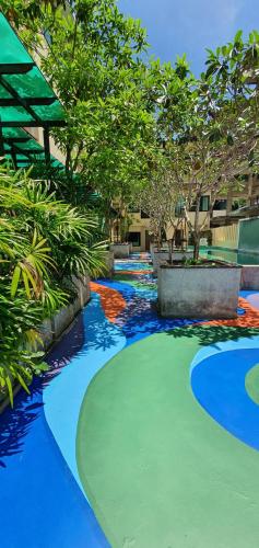 a colorful walkway in a building with trees at Royal Waves Hotel in Patong Beach
