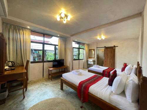 una camera da letto con due letti e una scrivania e una scrivania di Mesa Garden Villa a Chiang Mai