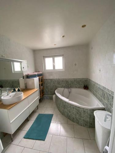 La salle de bains est pourvue d'une grande baignoire et d'un lavabo. dans l'établissement 