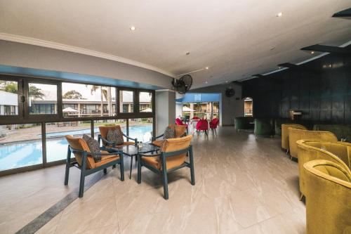 a dining room with a table and chairs and a pool at Happy Valley Hotel and Casino in Ezulwini