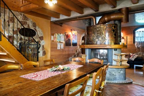 a kitchen with a wooden table and a fireplace at Baita Chalet Alabama in Arsiè