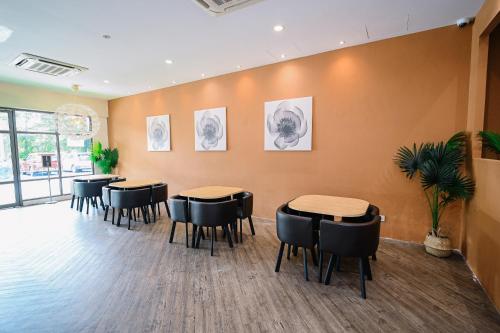 a waiting room with tables and chairs and drawings on the wall at Swing & Pillows - Z Hotel Cyberjaya in Cyberjaya