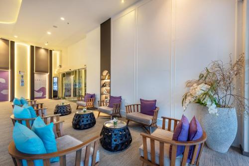 a lobby with couches and chairs and a table at PLAAI Prime Hotel Rayong SHA Extra Plus in Rayong