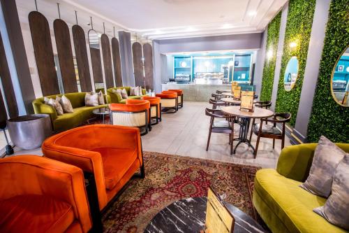 a restaurant with couches and tables and chairs at Happy Valley Hotel and Casino in Ezulwini