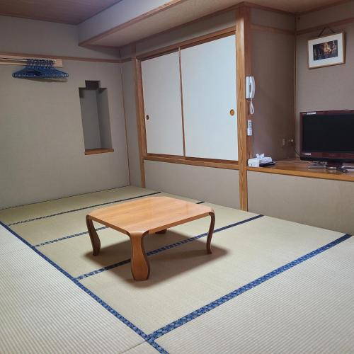 a room with a table in the middle of a room at Berg Marukaneya in Nozawa Onsen