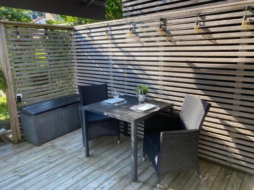 a table and chairs on a deck with a fence at Studio 51 Örgryte in Gothenburg