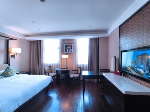 a hotel room with a bed and a flat screen tv at SSAW Boutique Hotel Hangzhou East - Free Self Service Laundry in Hangzhou