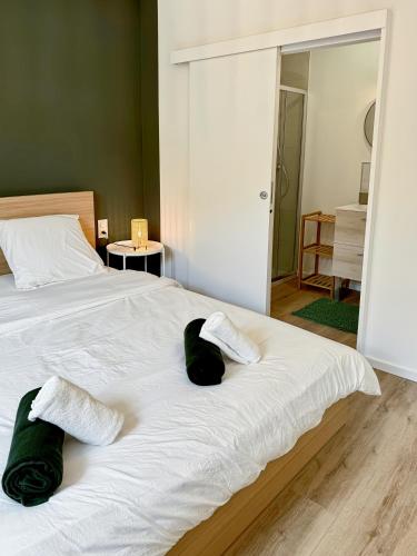 Una cama con dos almohadas verdes y blancas. en Une touche de vert, en Mulhouse