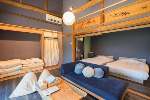 una camera con due letti e un divano blu di 由良民泊島宿 a Matsuyama